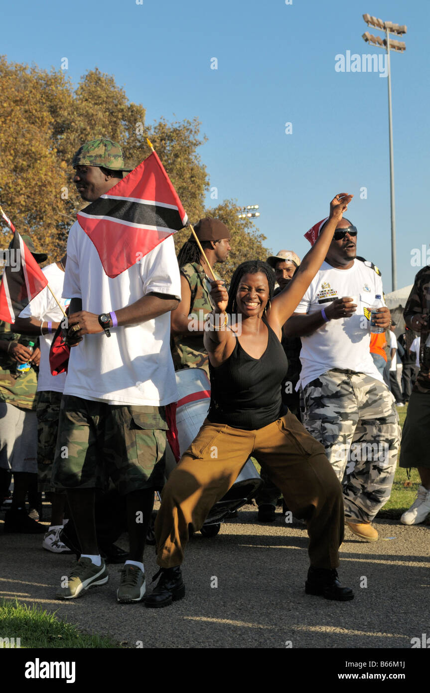 Celebrating female participant in the Caribbean Parade and Festival in Westchester Park proudly waving Trinidad and Tobago flag Stock Photo