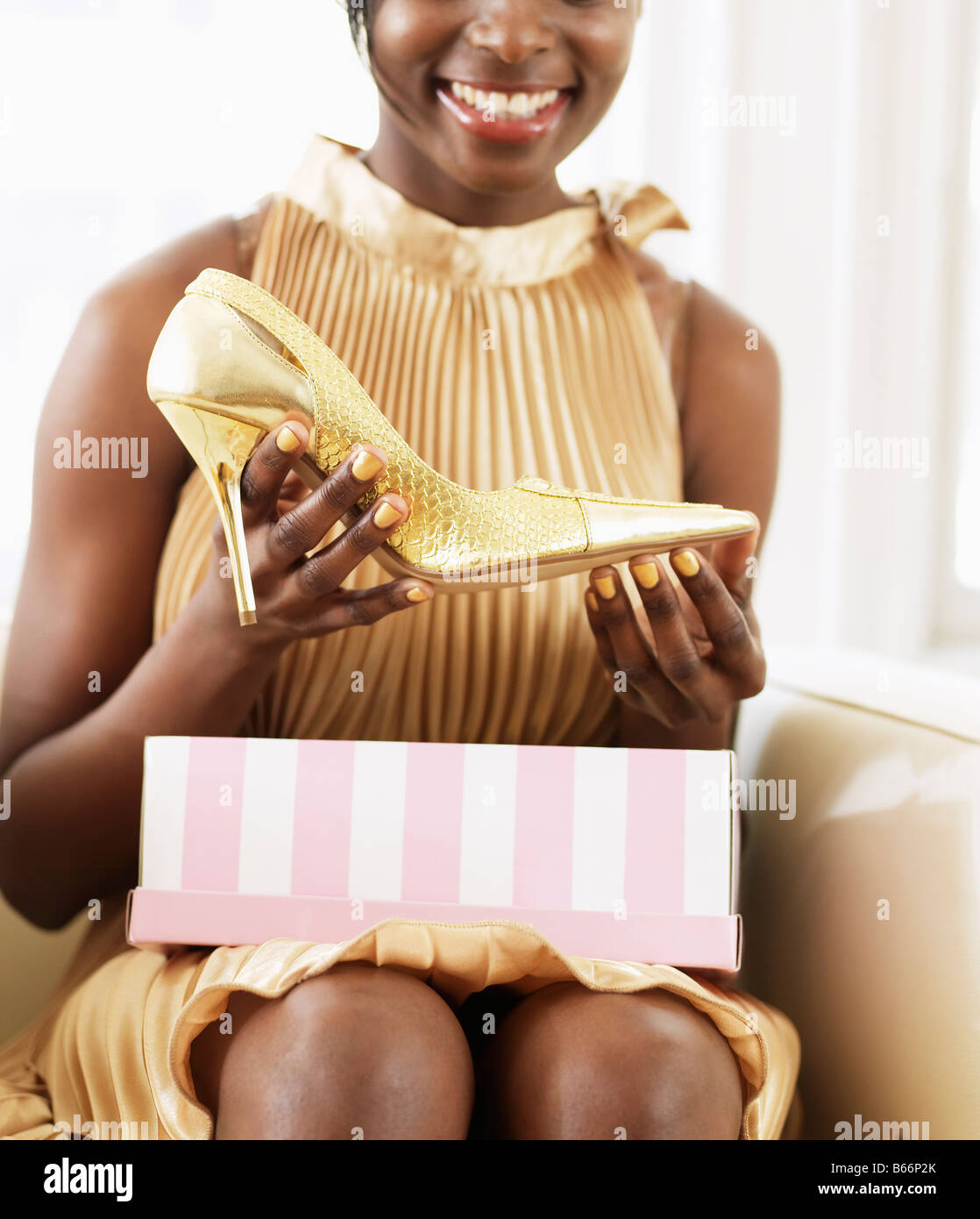 Young Woman Taking High-Heeled Shoe from Shoebox Stock Photo