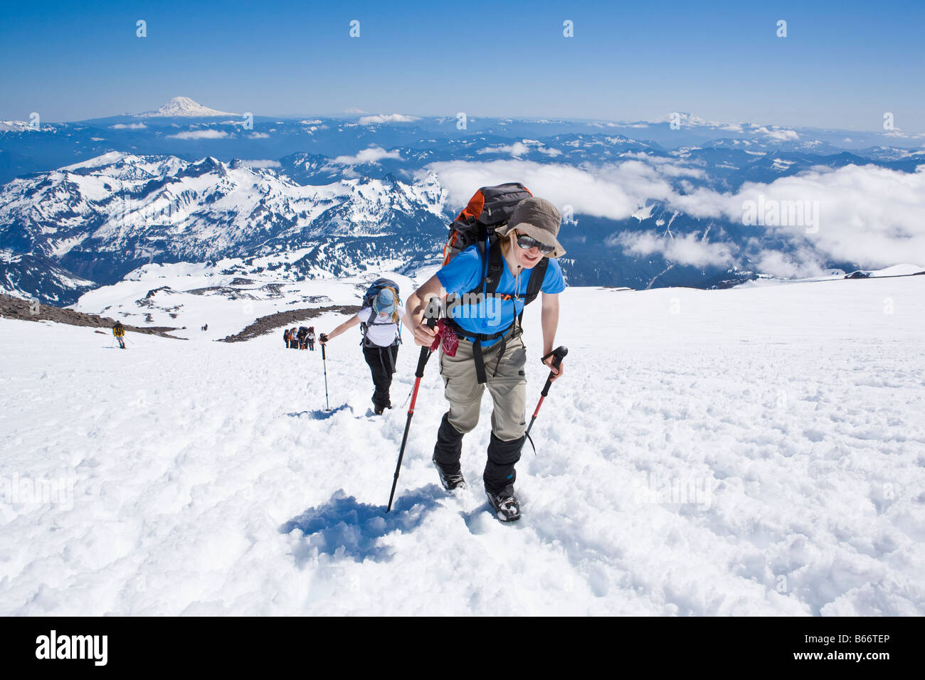 A mid 30's Caucasian woman and her friend hike up the Muir snow field ...