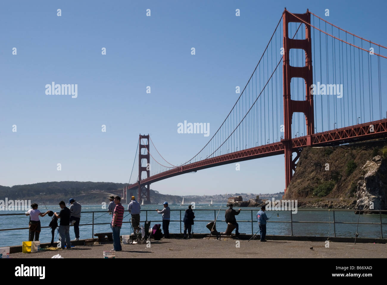 golden gate bridge from sausalito and some people fishing in the bay