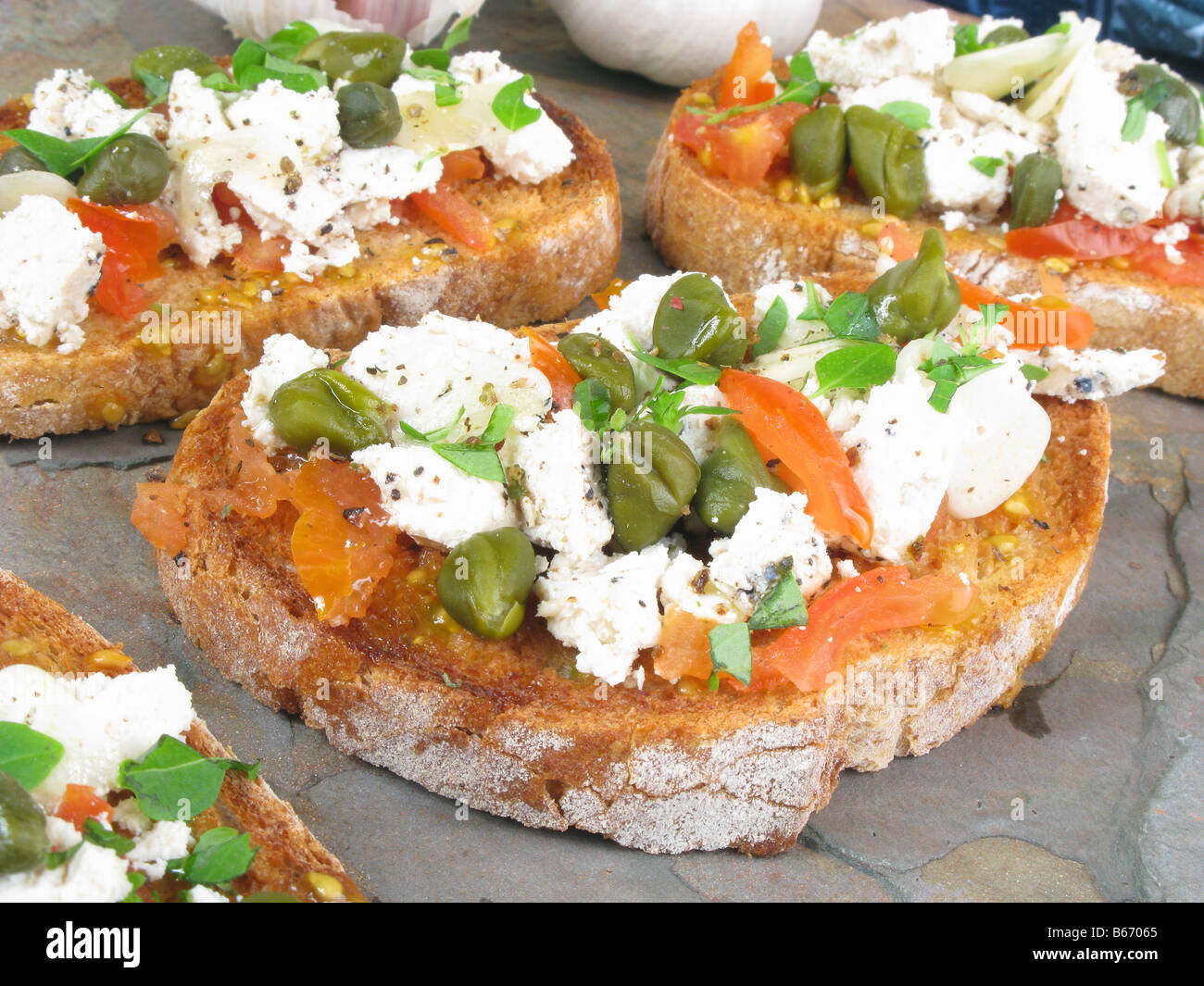 Maltese light meal of hobz-bi-zejt (bruschetta-style bread with oil), with tomatoes, capers, garlic and pepper gbejnet (cheese) Stock Photo