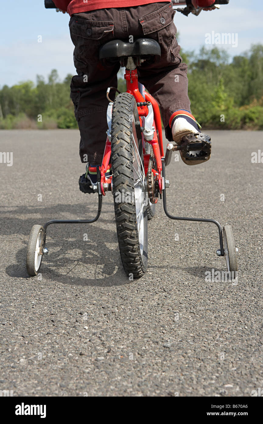 Child on a bicycle with stabilisers Stock Photo