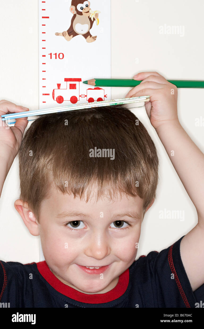 Boy measuring his height Stock Photo