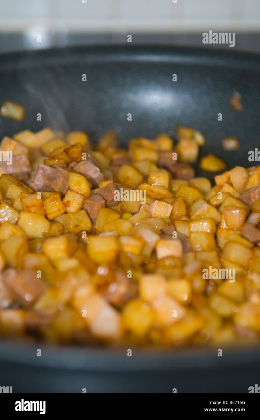 Fried diced meat with onions and potatoes on a stove Stock Photo Alamy