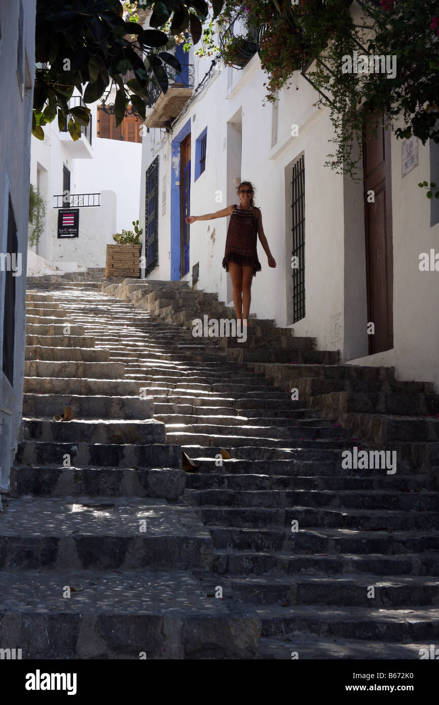 Young woman climbing the cobbled stairs of a street in Altea, Spain Stock Photo