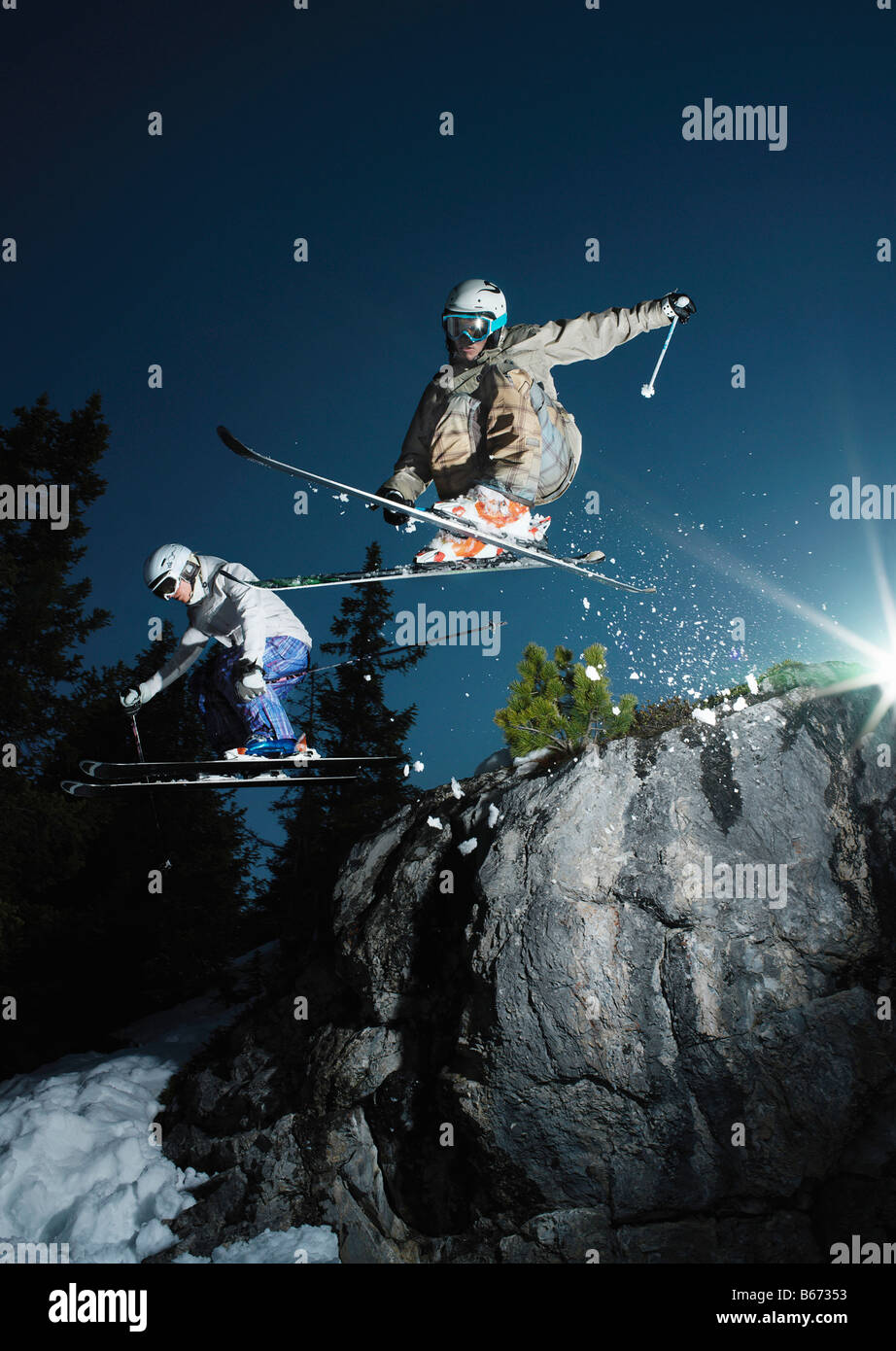 Skiers jumping over rock Stock Photo - Alamy