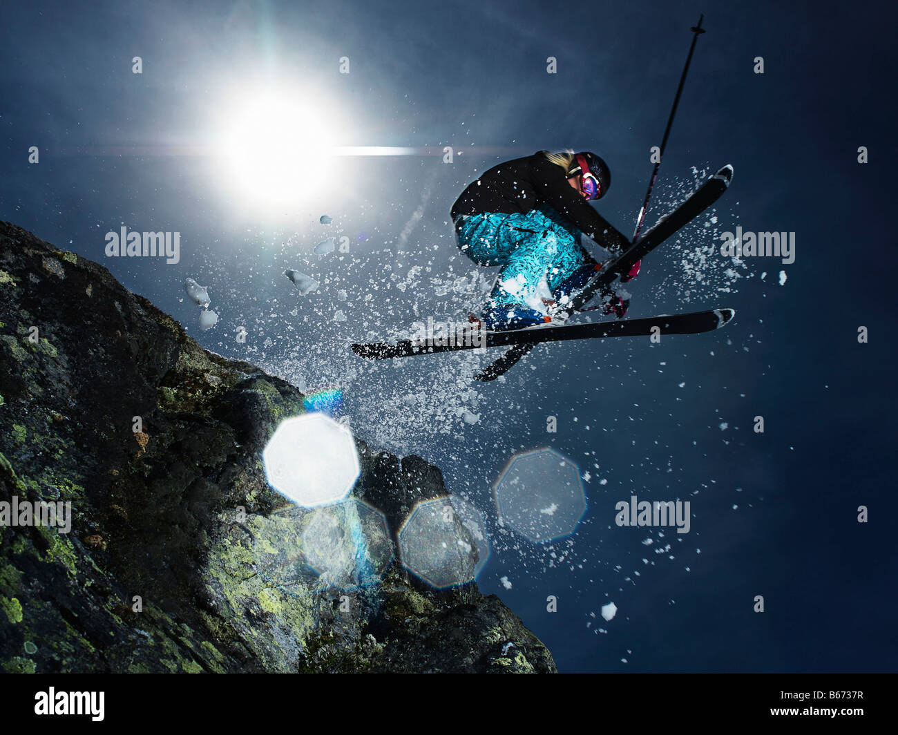 Female skier jumping over rock Stock Photo - Alamy
