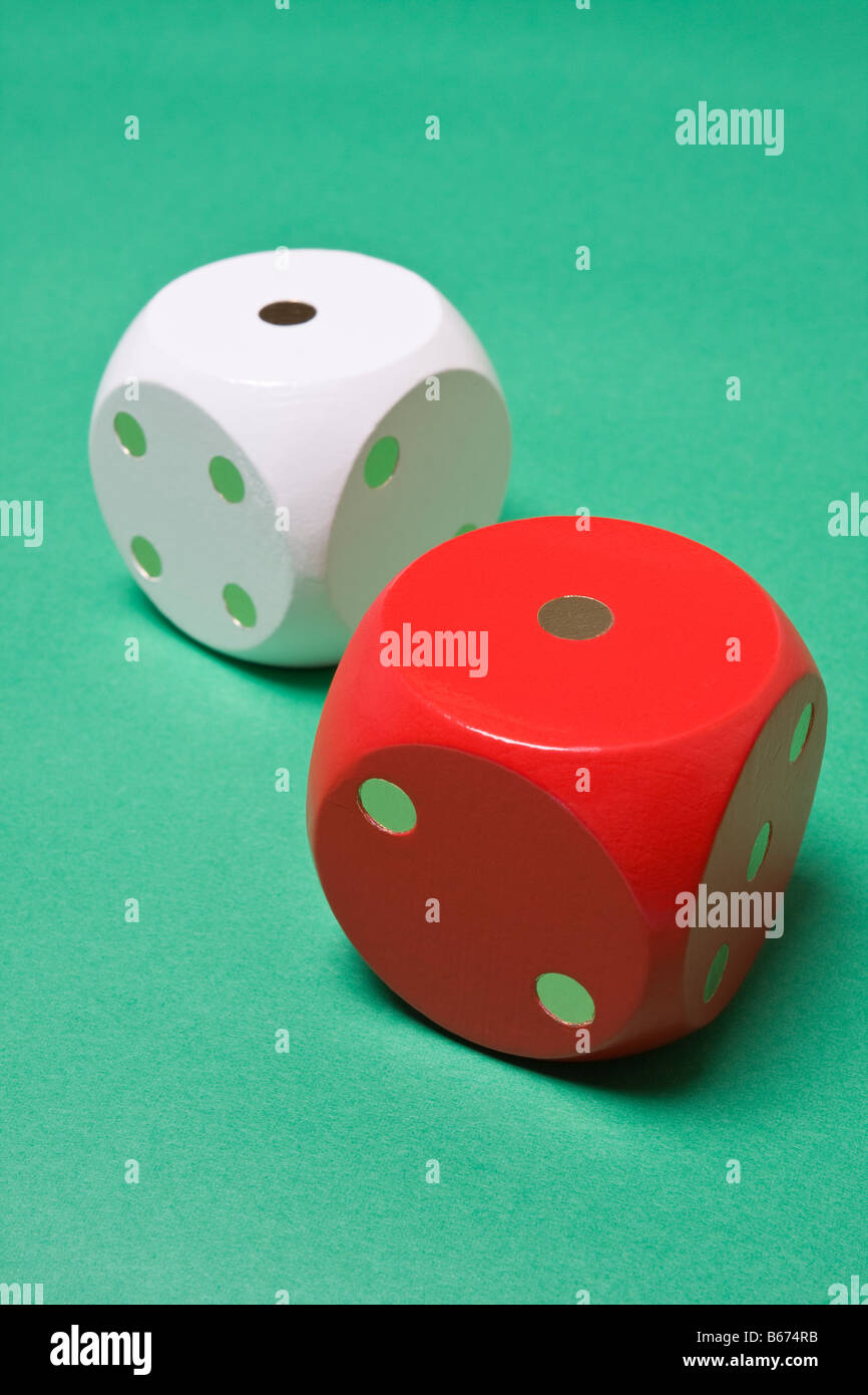 Red and white dice on green background showing double one Stock Photo