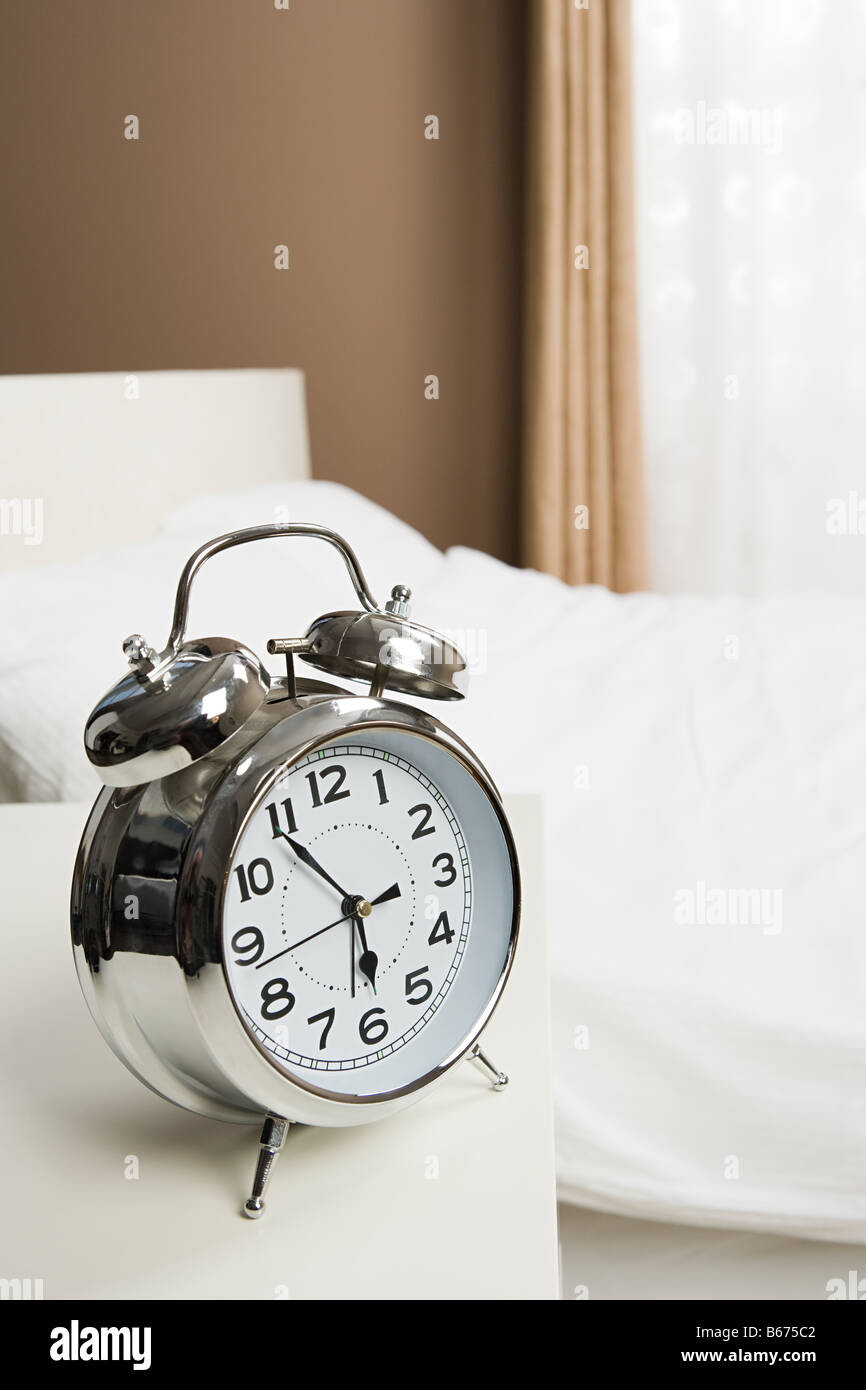 Alarm clock by bed Stock Photo Alamy