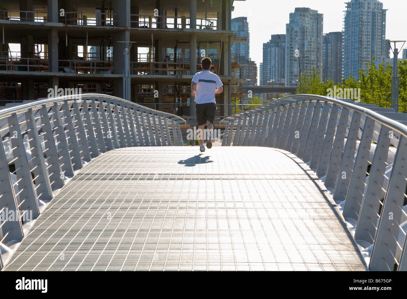 Runner on modern bridge 'Olympic Village building site' Vancouver 'British Columbia' Canada Stock Photo