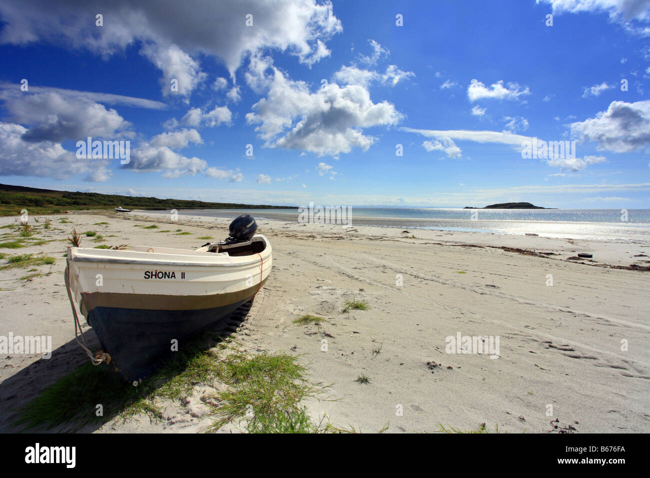 Boat on Jura beach 'loch na mile' looking out to the small isles, Scotland Stock Photo