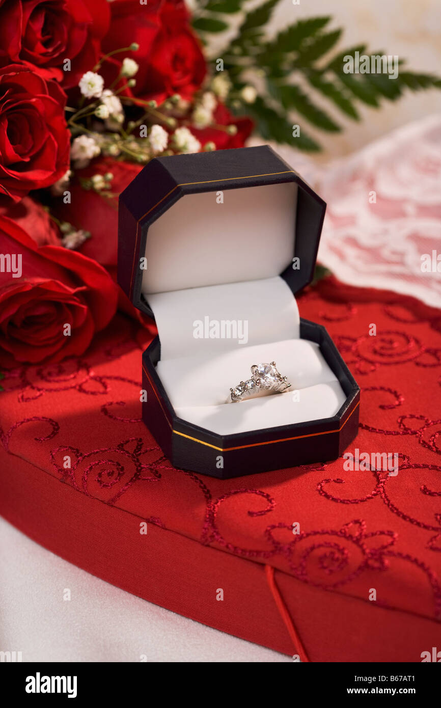 Engagement ring in display box and red roses Stock Photo