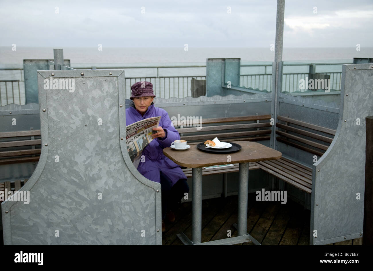 An elderly lady having coffee alone, The Pier, Southwold, Suffolk, England Stock Photo