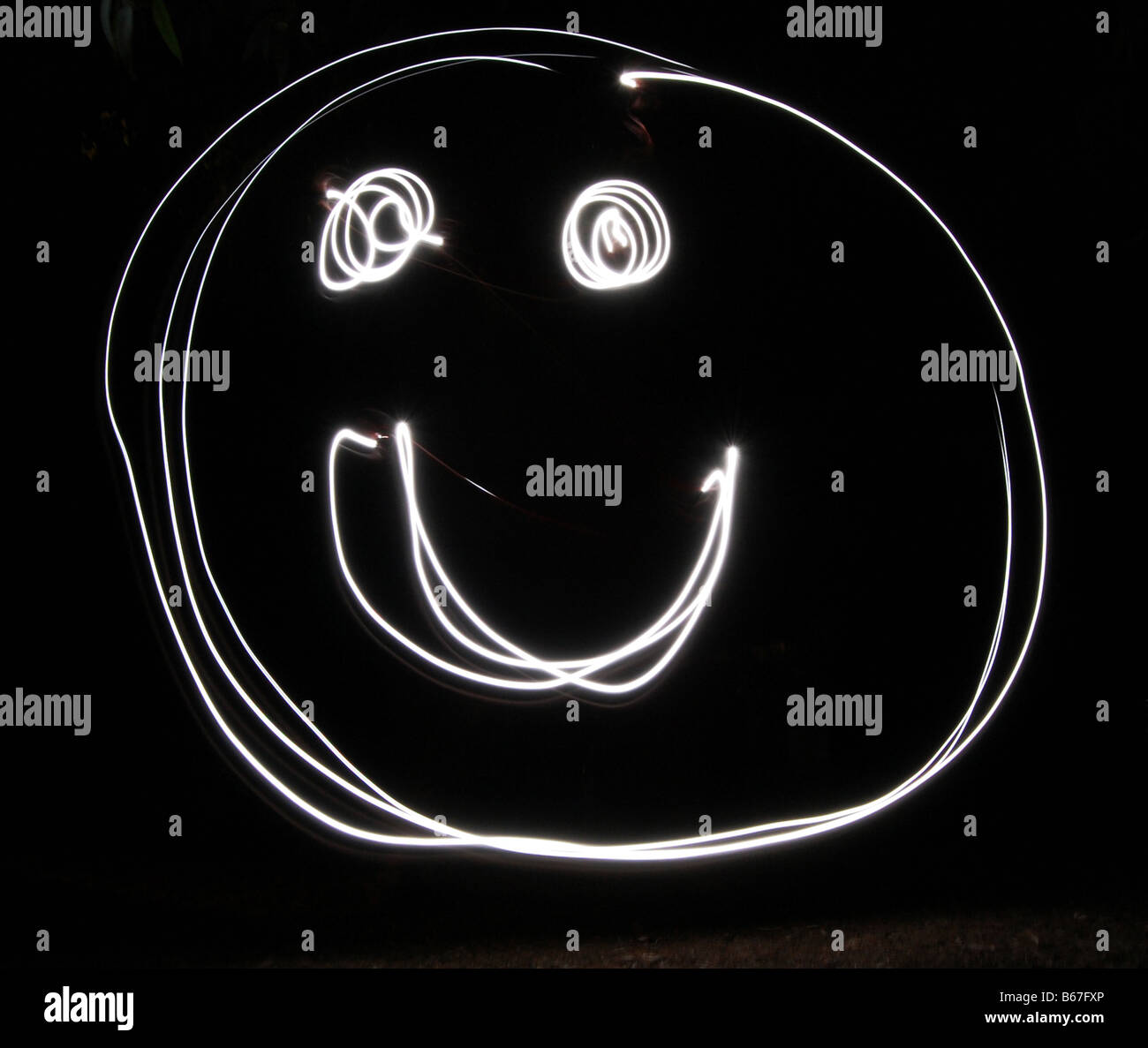 Smiley face written with a torch using long exposure Stock Photo