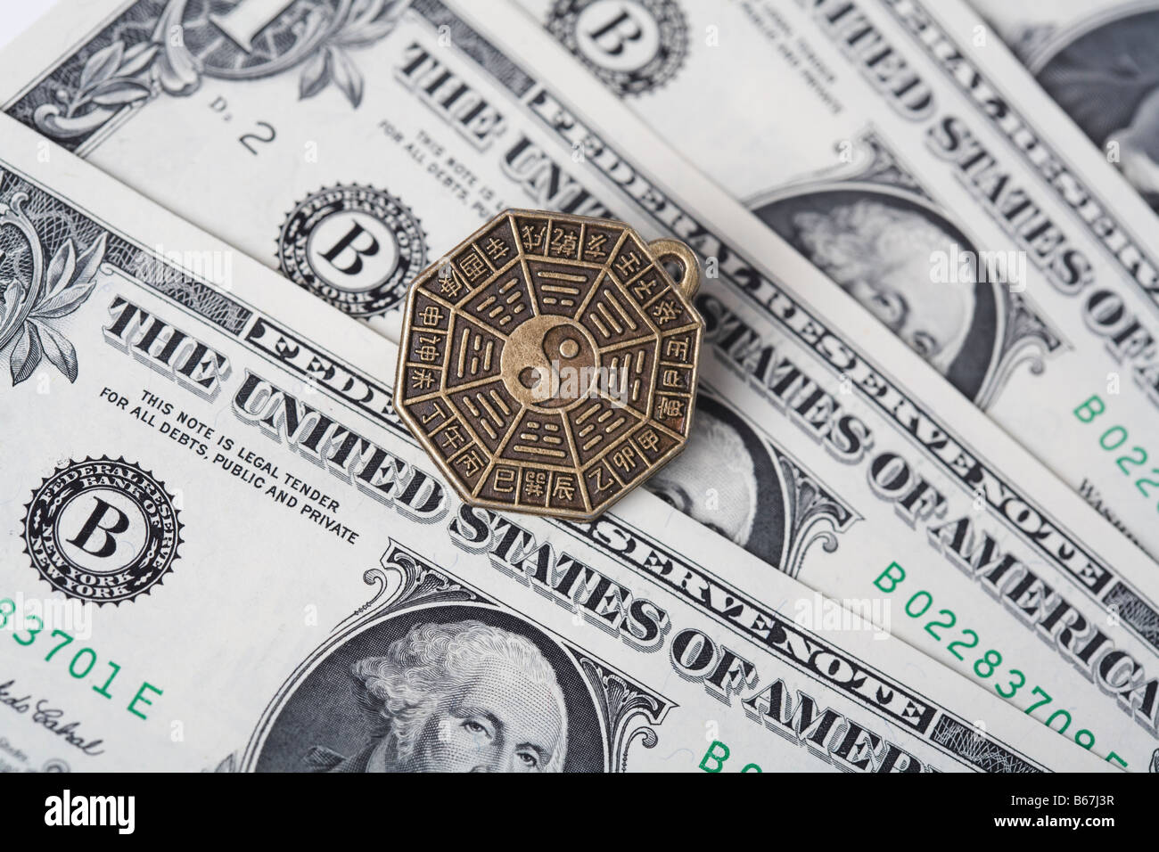 Close-up of a Chinese coin over US paper currency Stock Photo