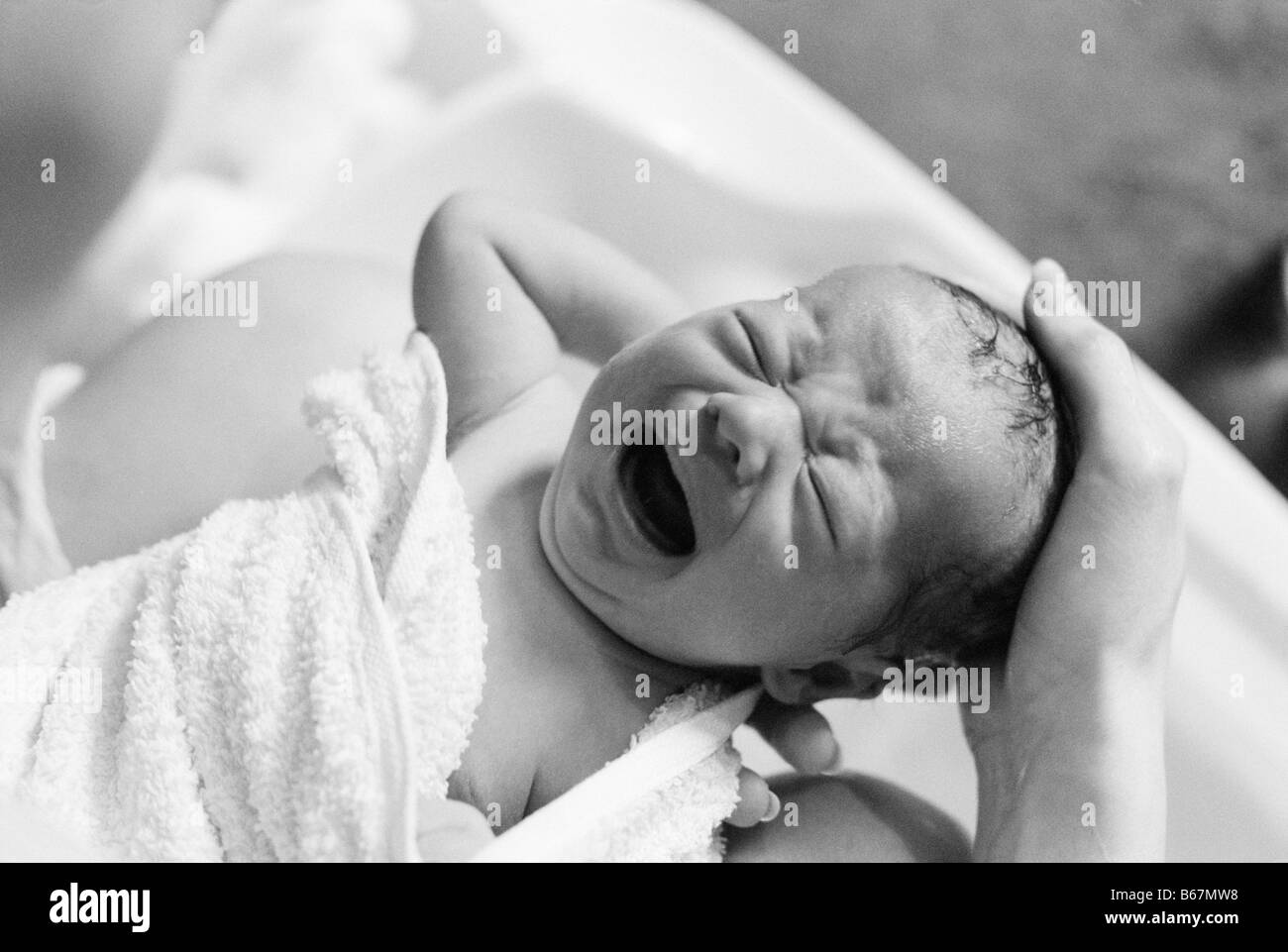 Baby boy having hair washed in bath Stock Photo