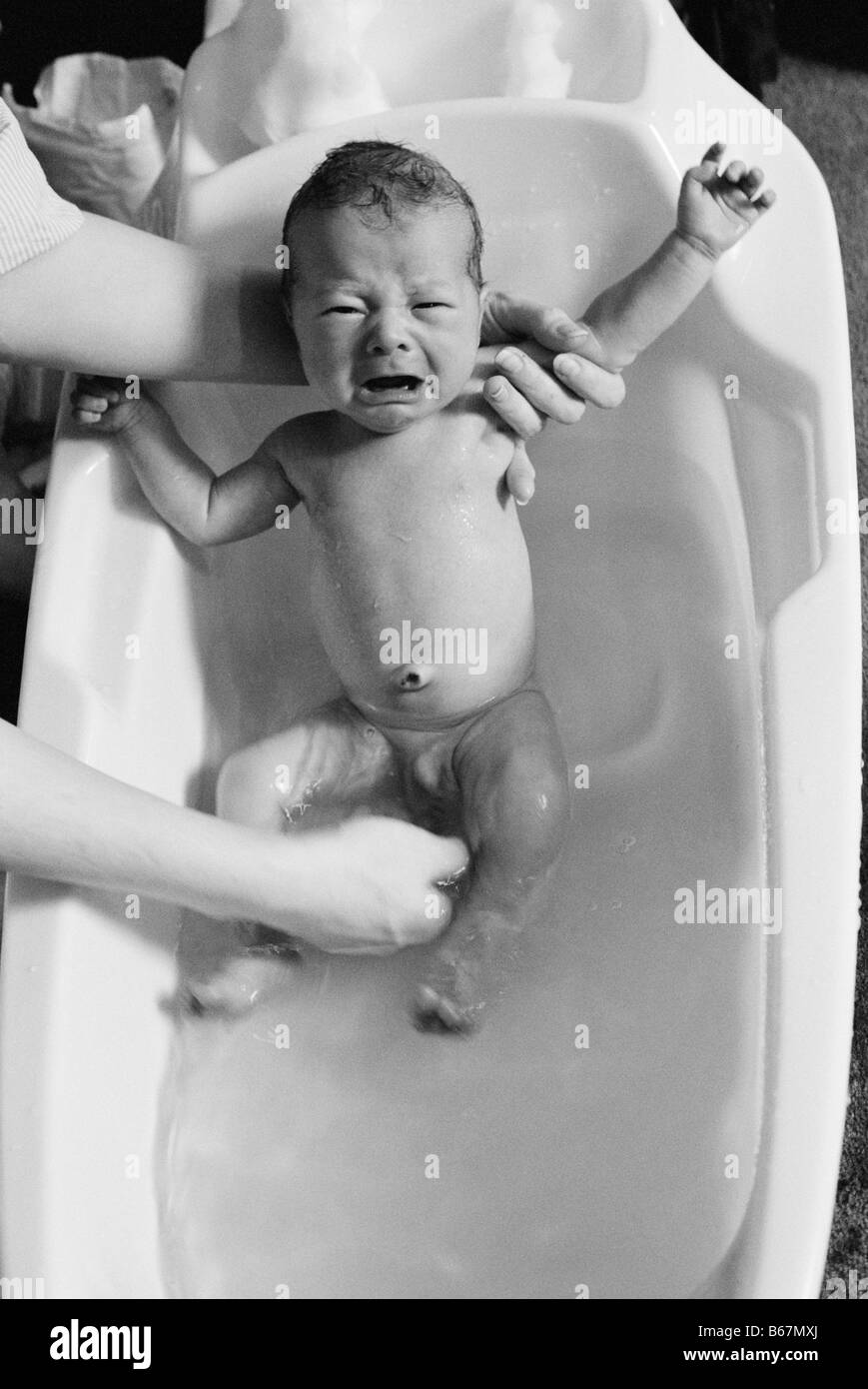 Baby boy having hair washed in bath Stock Photo