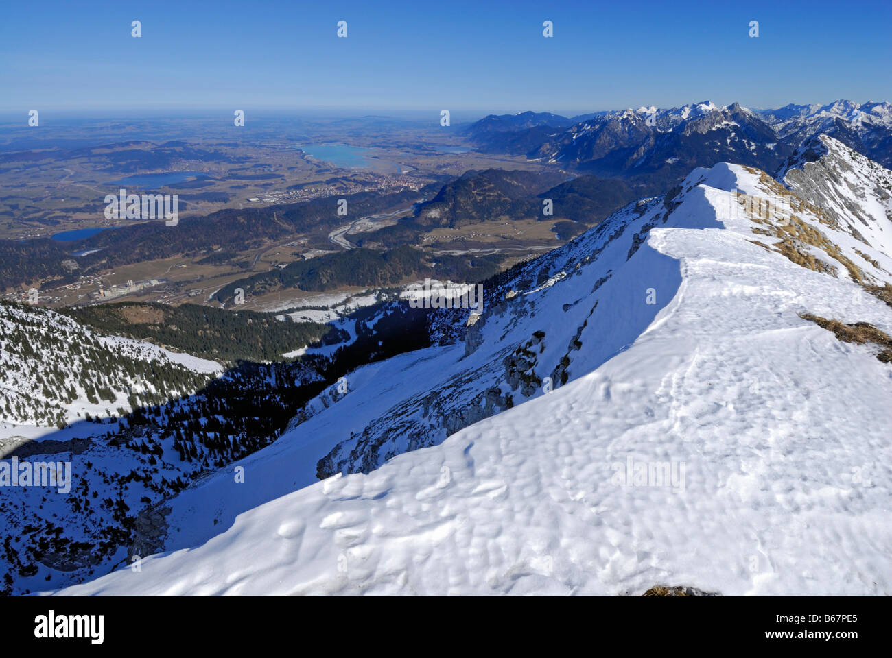 view from snow-covered summit of Grosse Schlicke to lake Weissensee, Hopfensee, Forggensee and Bannwaldsee, Tannheim range, Allg Stock Photo