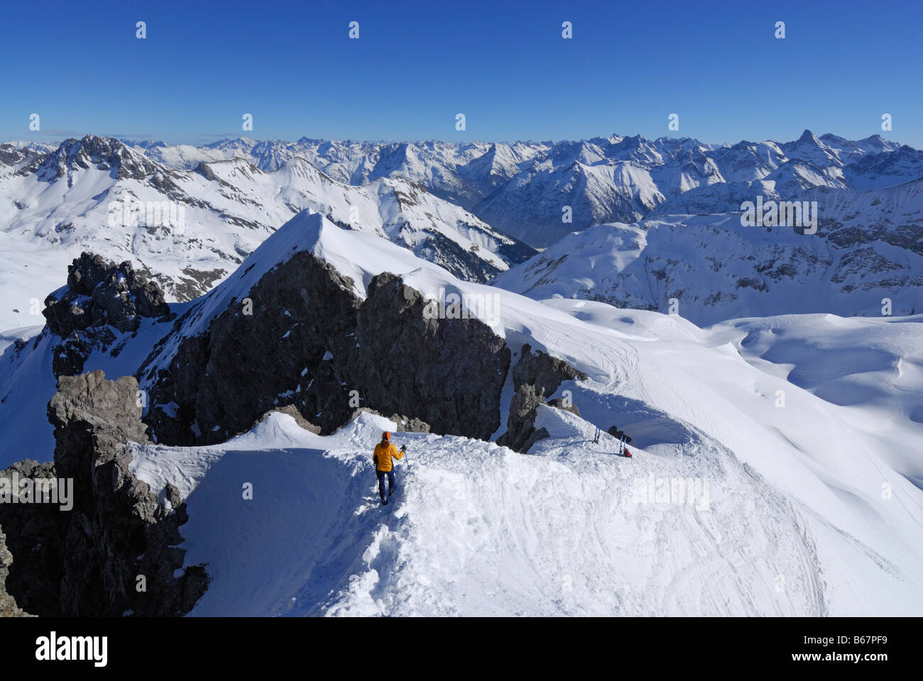 young woman descending from Maedelegabel with view to Lechtal range, Allgaeu range, Allgaeu, Swabia, Bavaria, Germany Stock Photo