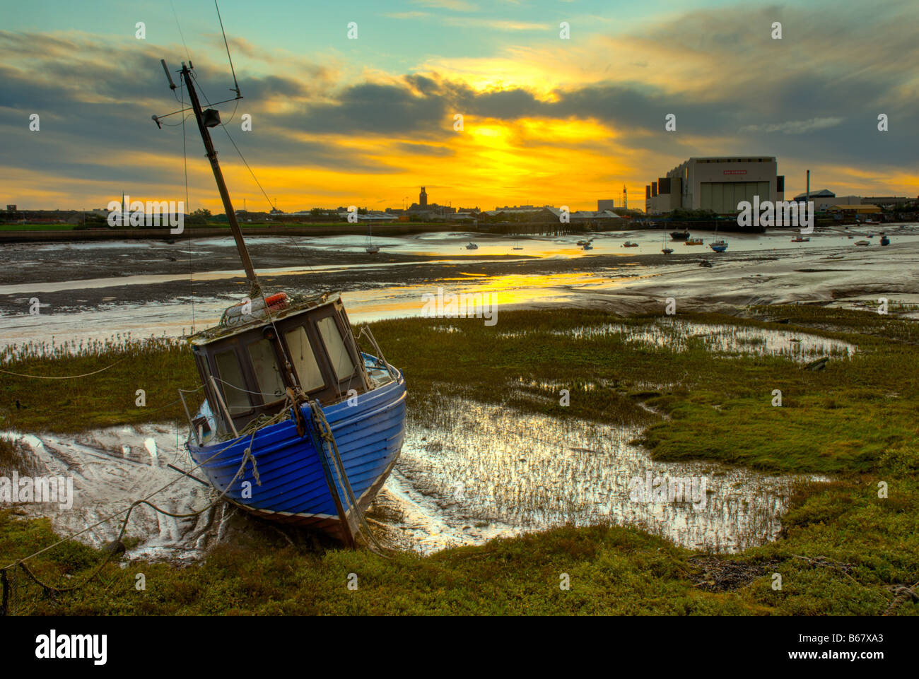 Fishing boated at low tide on Walney Channel, looking towards BAE Systems shipyard and Barrow-in-Furness, Cumbria, England UK Stock Photo