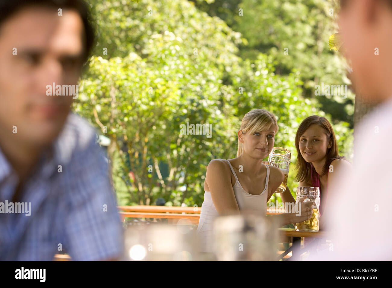 Flirt in beer garden, Two young women and two men flirting in a beer garden, Lake Starnberg, Bavaria, Germany Stock Photo