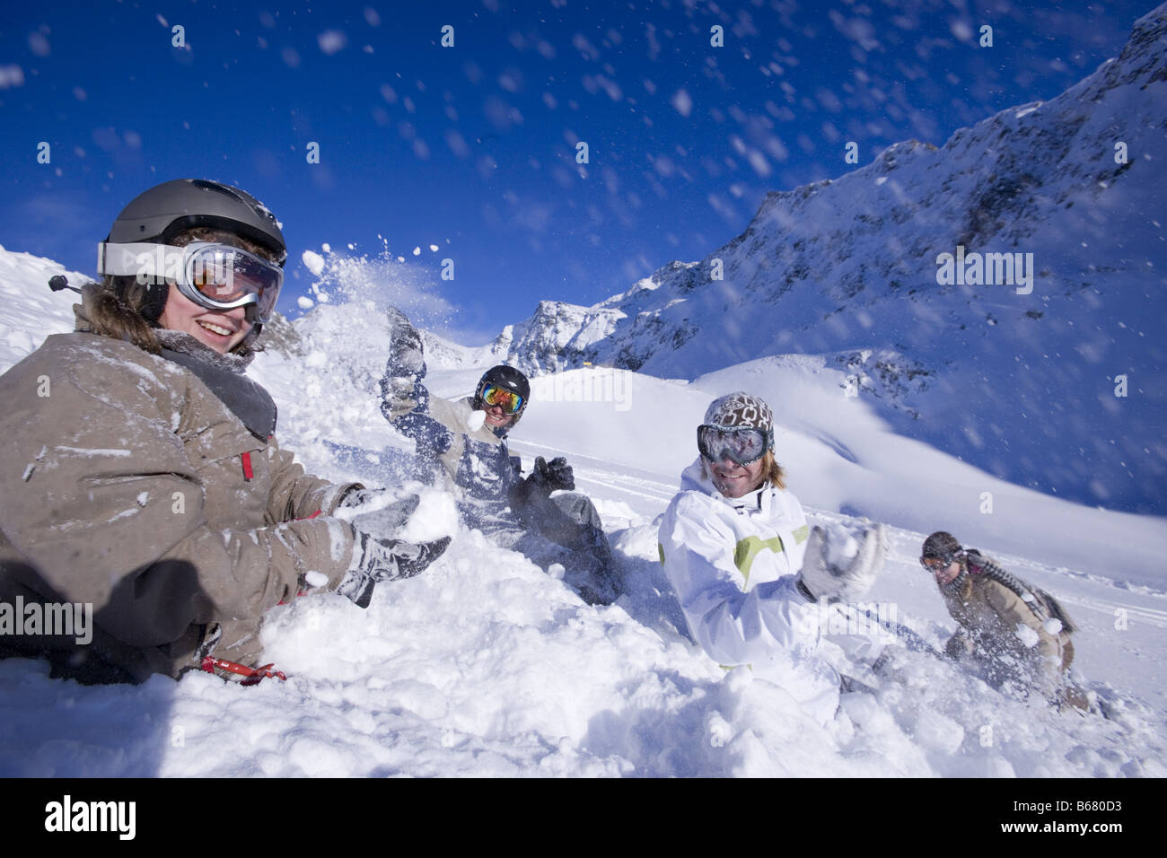 Young people having fun with snowball fight, sitting on snow, Kuehtai, Tyrol, Austria Stock Photo