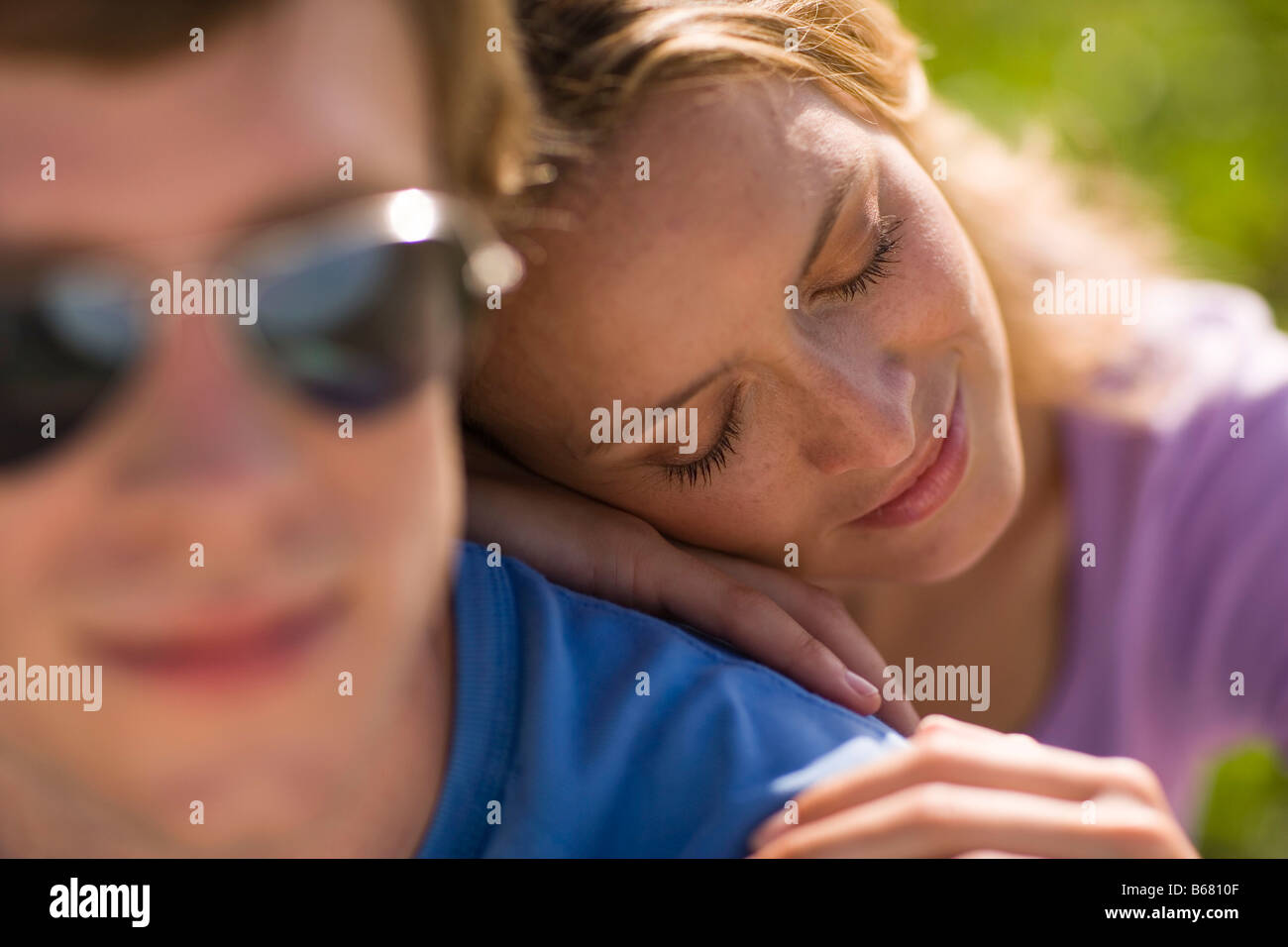 Woman leaning head on man's back Stock Photo
