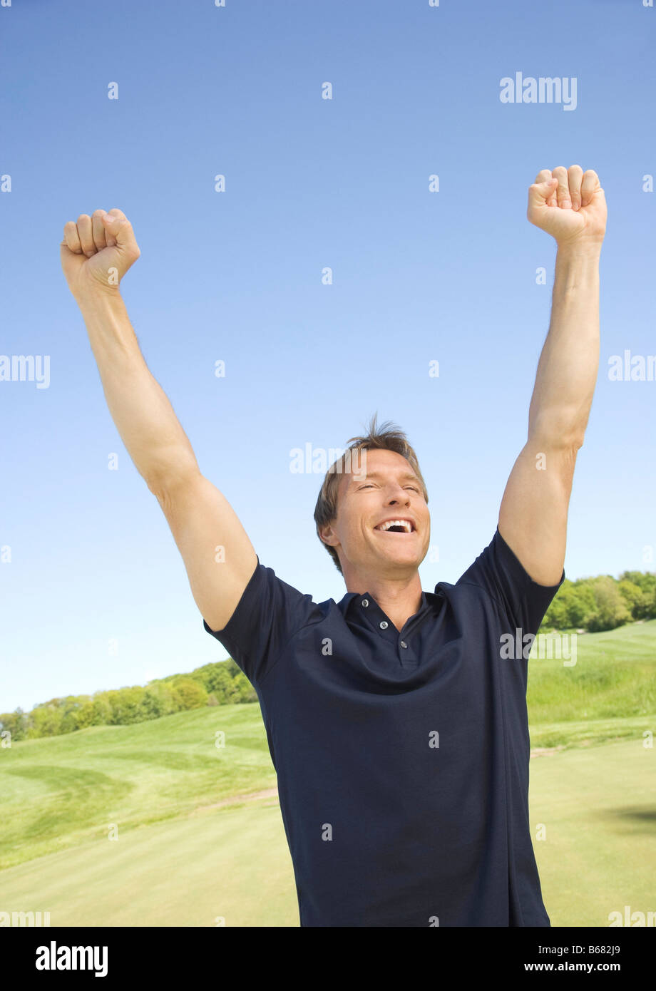 Happy handsome man cheering arms hi-res stock photography and images ...