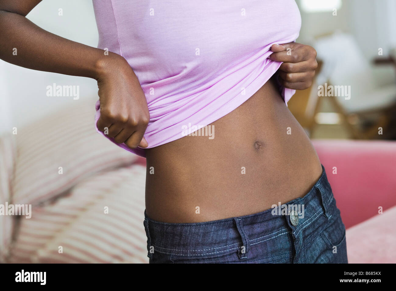 Woman Lifting Shirt to Show Stomach Stock Photo - Alamy