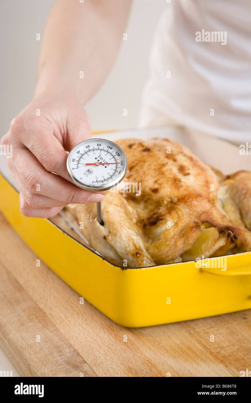 Woman Checking Temperature of Chicken Stock Photo Alamy