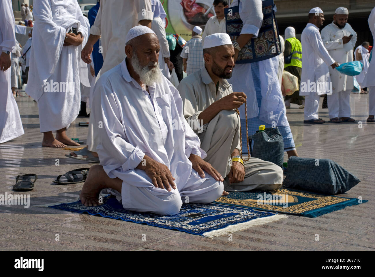 An old and a young Muslim man sitting on their prayer rugs Makkah Saudi Arabia Stock Photo Alamy