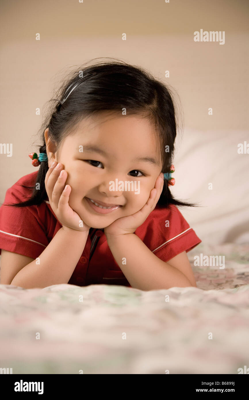 Portrait of a girl lying on the bed and smiling Stock Photo - Alamy