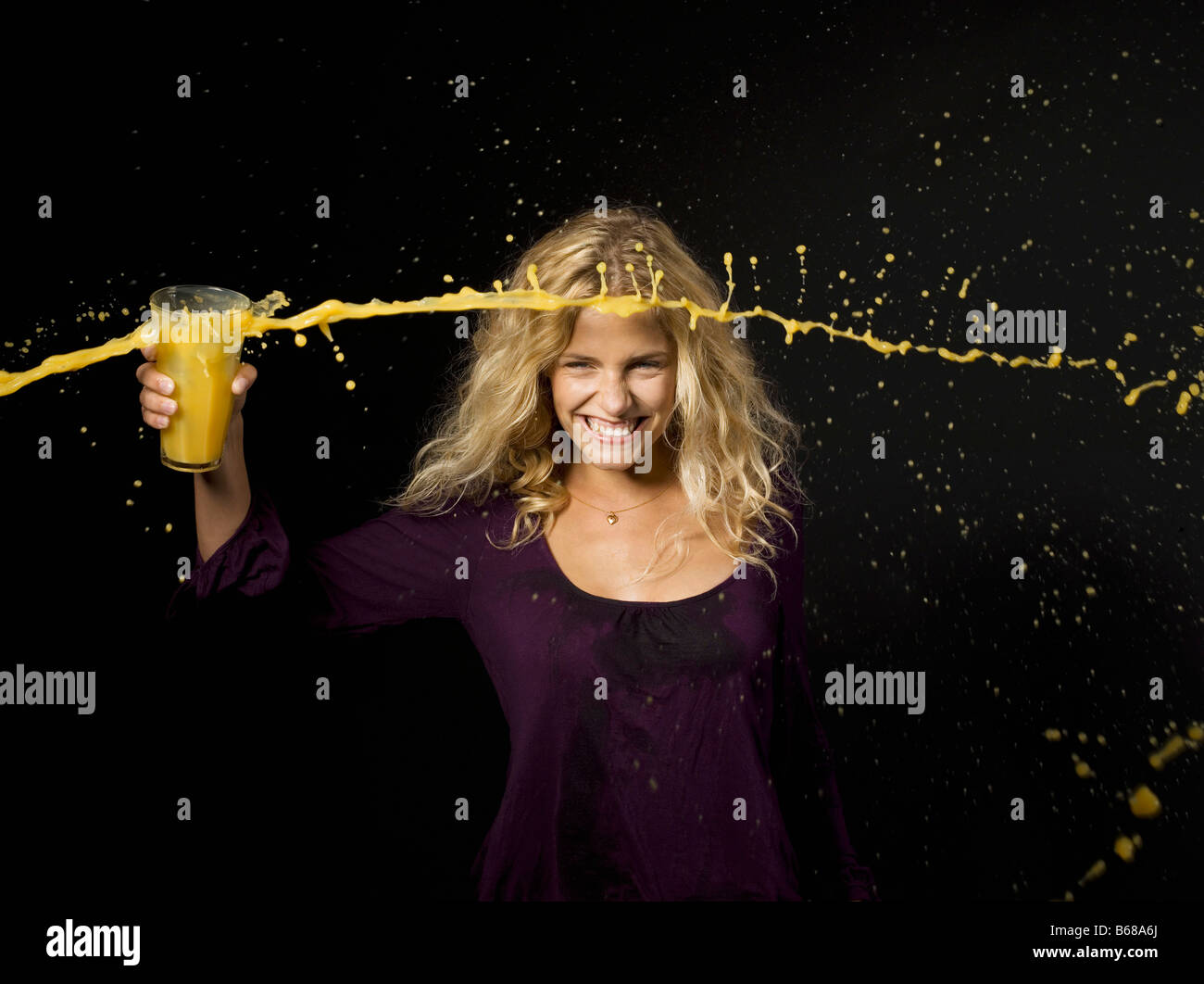 Woman throwing orange juice from a glass Stock Photo Alamy
