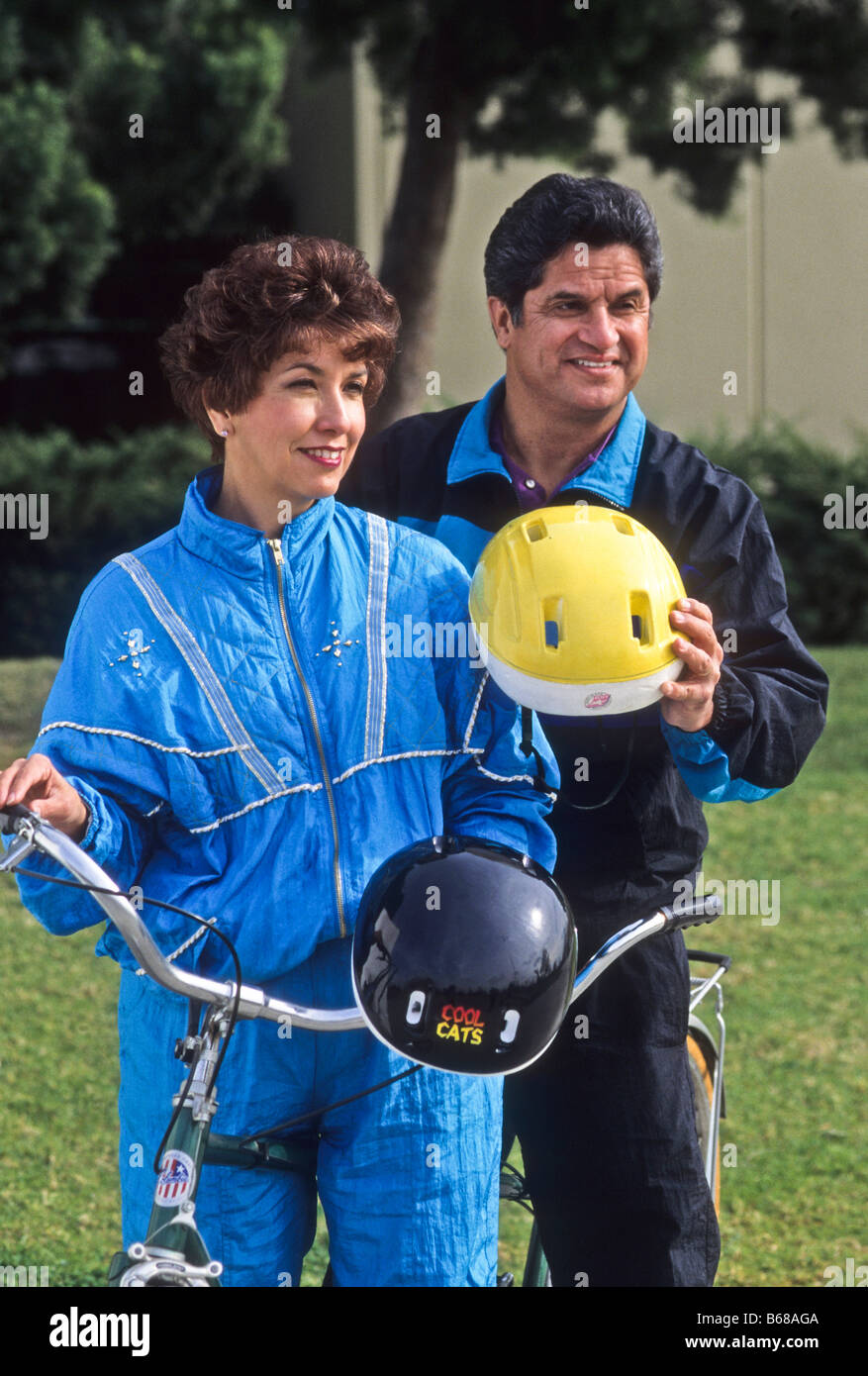 Hispanic couple ride tandem bike with helmets. Stock Photo