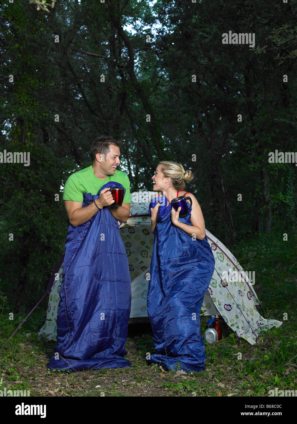 Couple jumping in sleeping bags Stock Photo