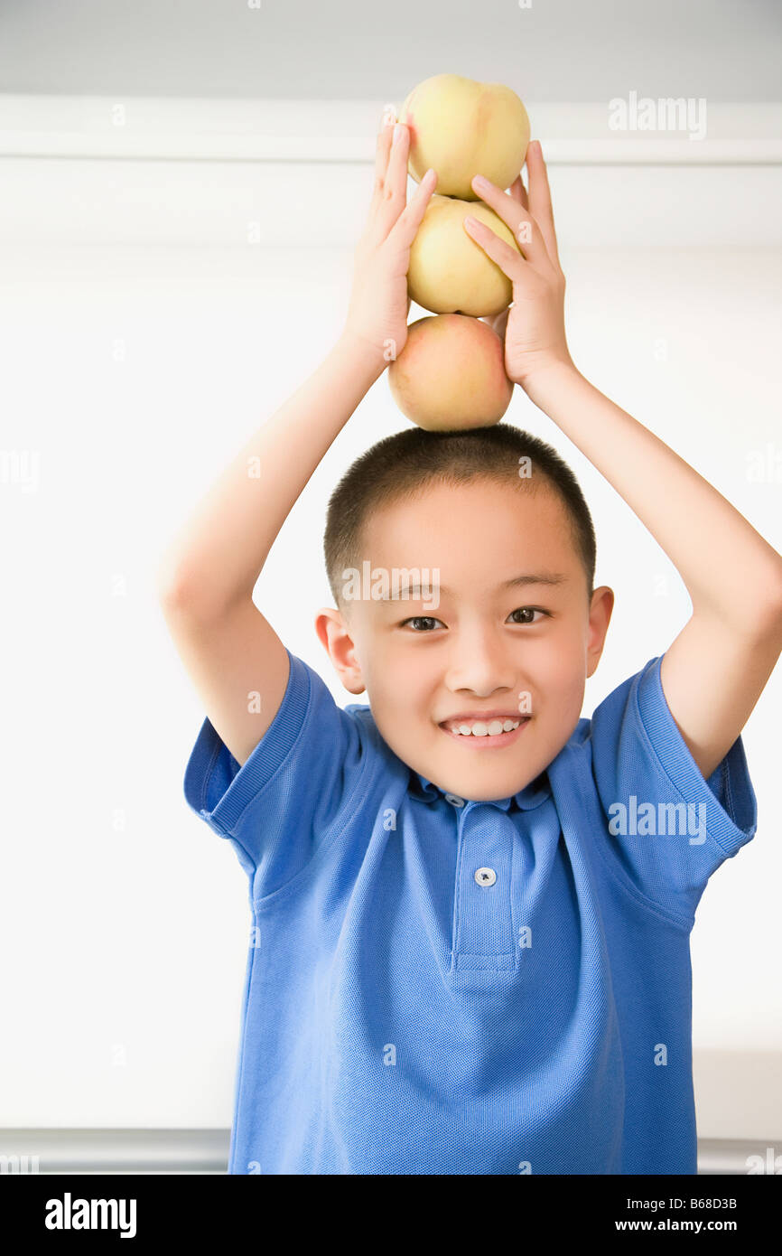 Portrait of a boy balancing apples on his head Stock Photo Alamy