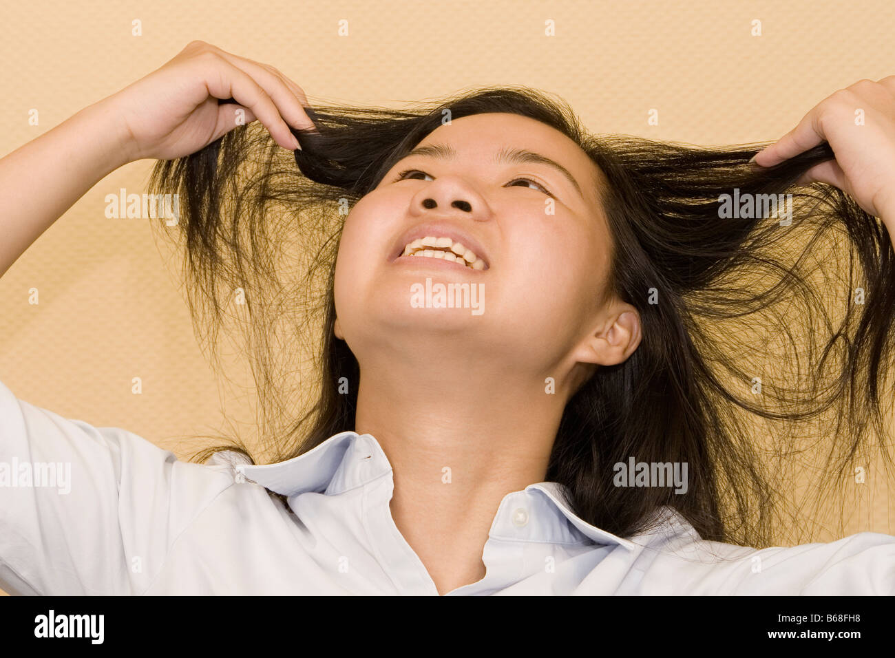 Close-up of a young woman holding her hair and smiling Stock Photo
