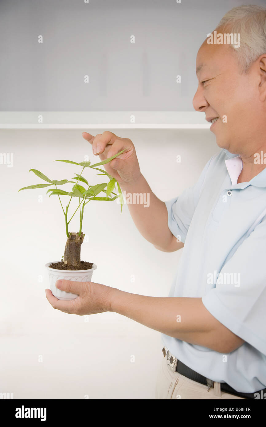 Side profile of a mature man holding a potted plant Stock Photo - Alamy