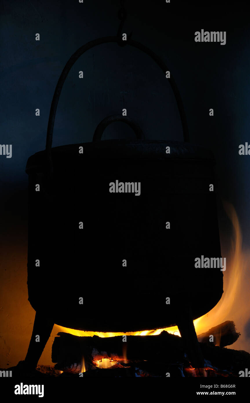 Stock photo of a cast iron cauldron hanging over an open fireplace