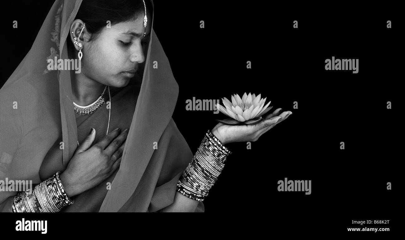 Indian woman offering a Nymphaea Tropical waterlily flower in a sari. Monochrome. Andhra Pradesh, India Stock Photo