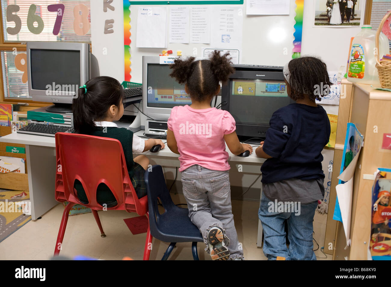 4 year old preschool children at computers in the classroom Stock Photo