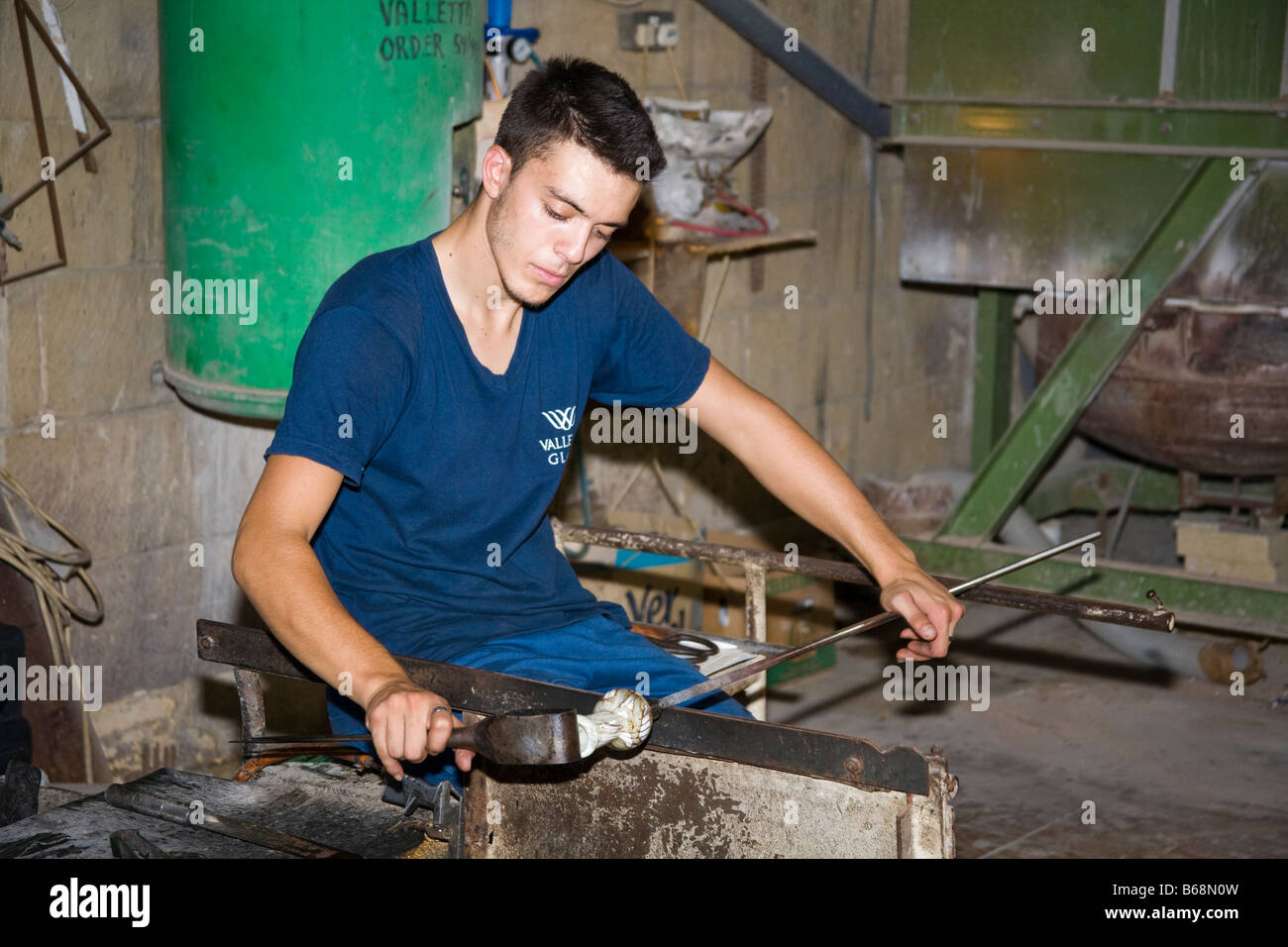 Glass blower manufacturing a glass ornament, Valletta Glass factory, Ta