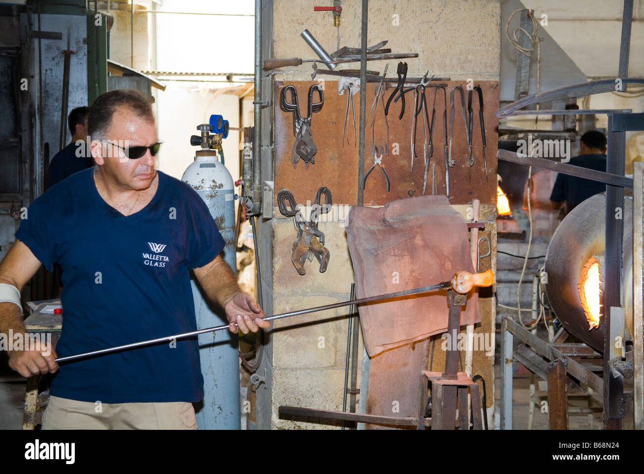 Glass blower manufacturing a glass ornament, Valletta Glass factory, Ta