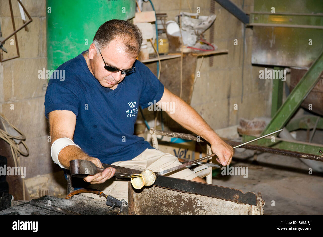 Glass blower manufacturing a glass ornament, Valletta Glass factory, Ta