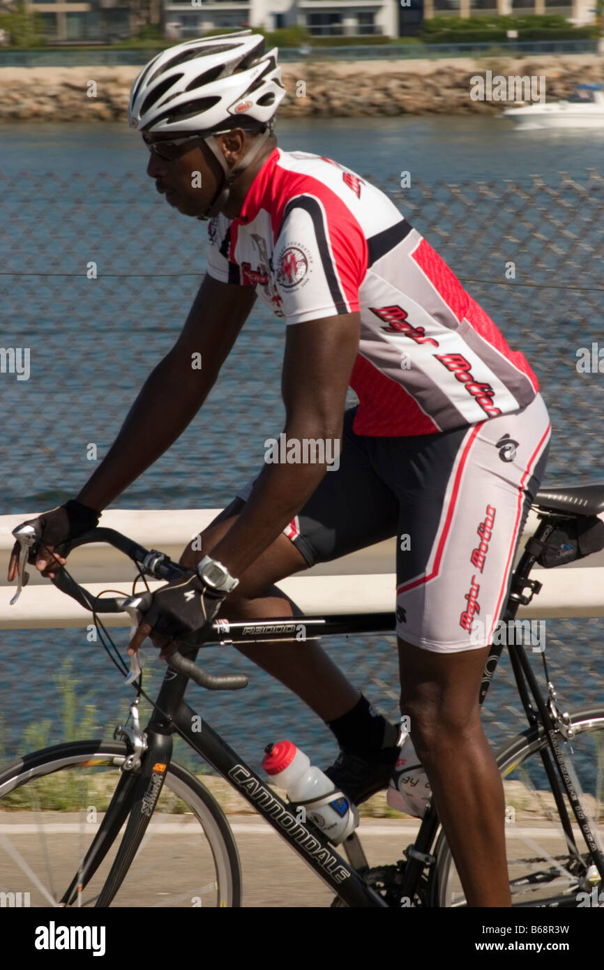 cyclist in red white jersey going by Stock Photo