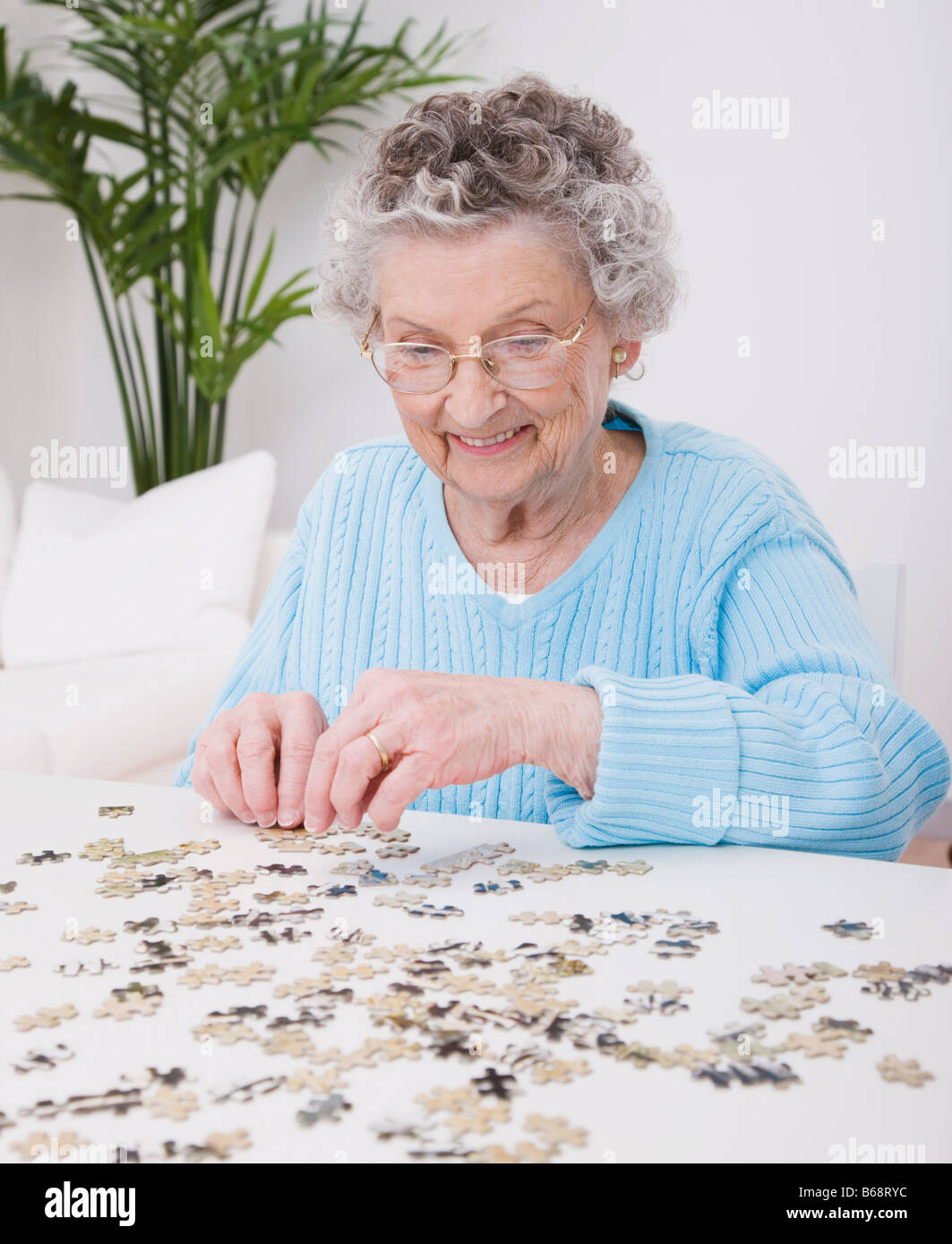 Senior woman doing jigsaw puzzle Stock Photo