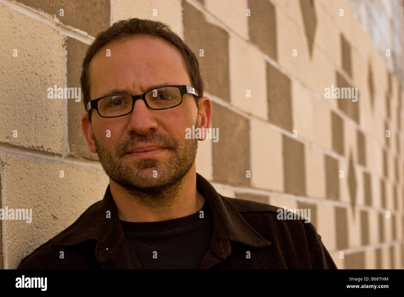 Male Model With Short Hair Wearing Glasses Against A White And