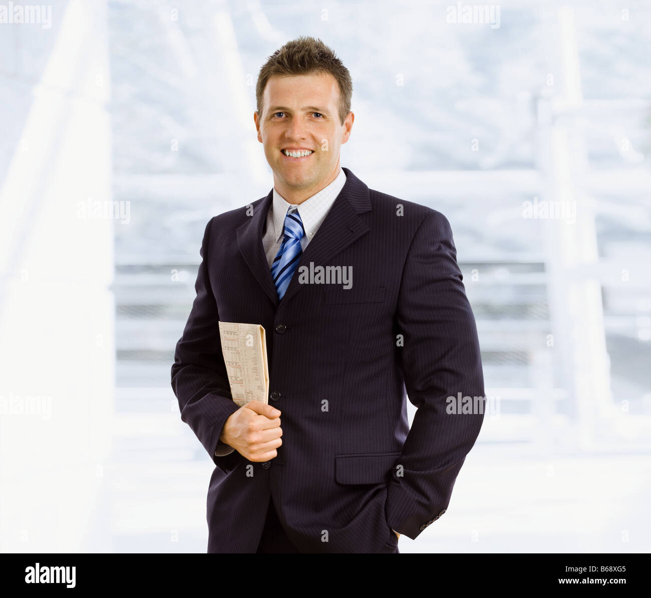 Happy businessman holding newspaper indoor smiling Stock Photo - Alamy