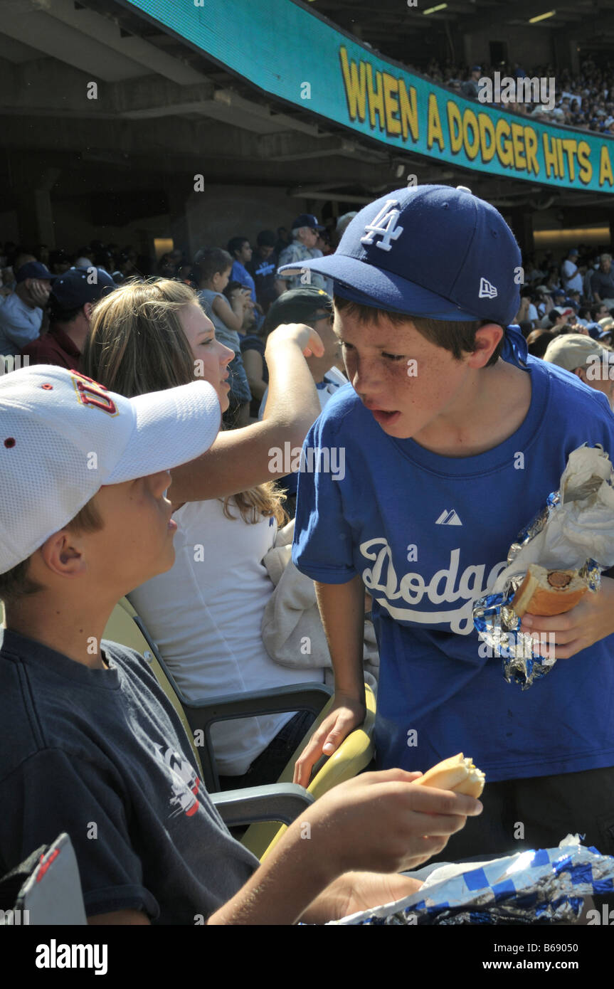 Two young baseball fans in intense discussion during game Stock Photo