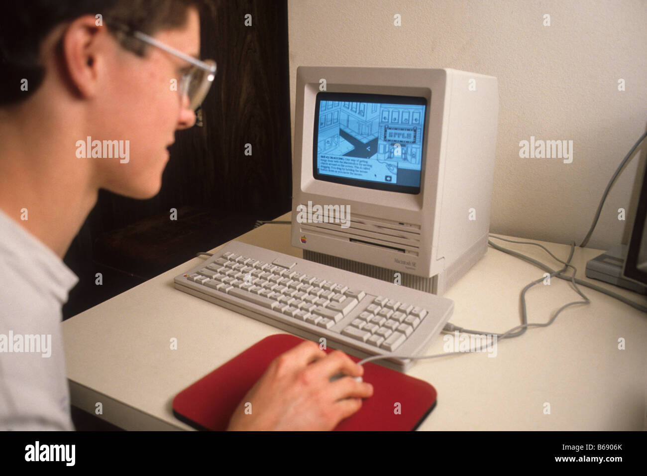 Teen boy works on early model Macintosh computer Stock Photo - Alamy